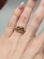 Gold ring in a knotted design, with 6
Round Diamonds flush set into the gold worn on the hand. 9ct Yellow gold. Pretzel ring. 